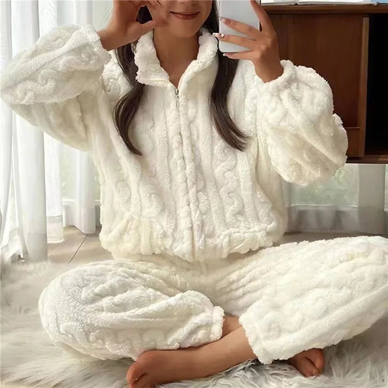 Frau in weißem, flauschigem Fleece-Pyjama-Set, sitzt auf Teppich, gemütliche Winterkleidung.