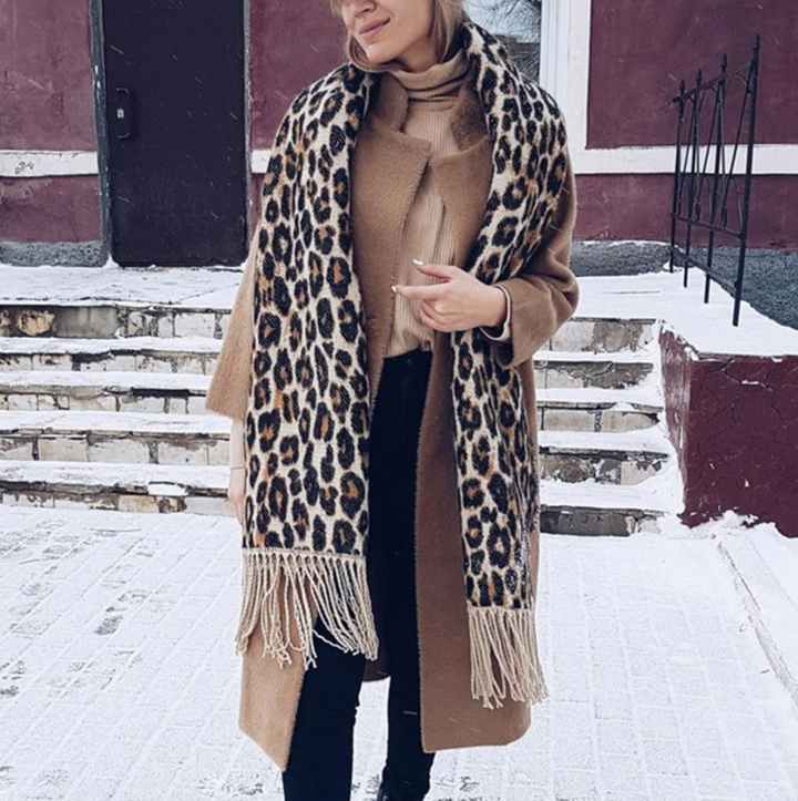 Frau mit braunem Mantel und Leopardenmuster-Schal im Schnee, Wintermode, stilvoll, warm.