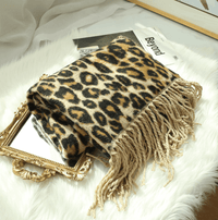 Leopardenmuster Decke mit Fransen auf Spiegel, luxuriöses Wohnaccessoire, weiches Material.