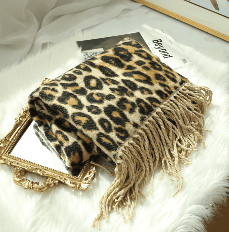 Leopardenmuster Decke mit Fransen auf Spiegel, luxuriöses Wohnaccessoire, weiches Material.