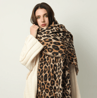 Frau mit Leopardenmuster-Schal und cremefarbenem Strickpullover, modisch, elegant.