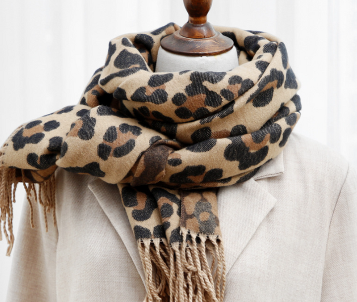 Leopardenmuster Schal aus Wolle, beige und braun, auf beigem Mantel drapiert.