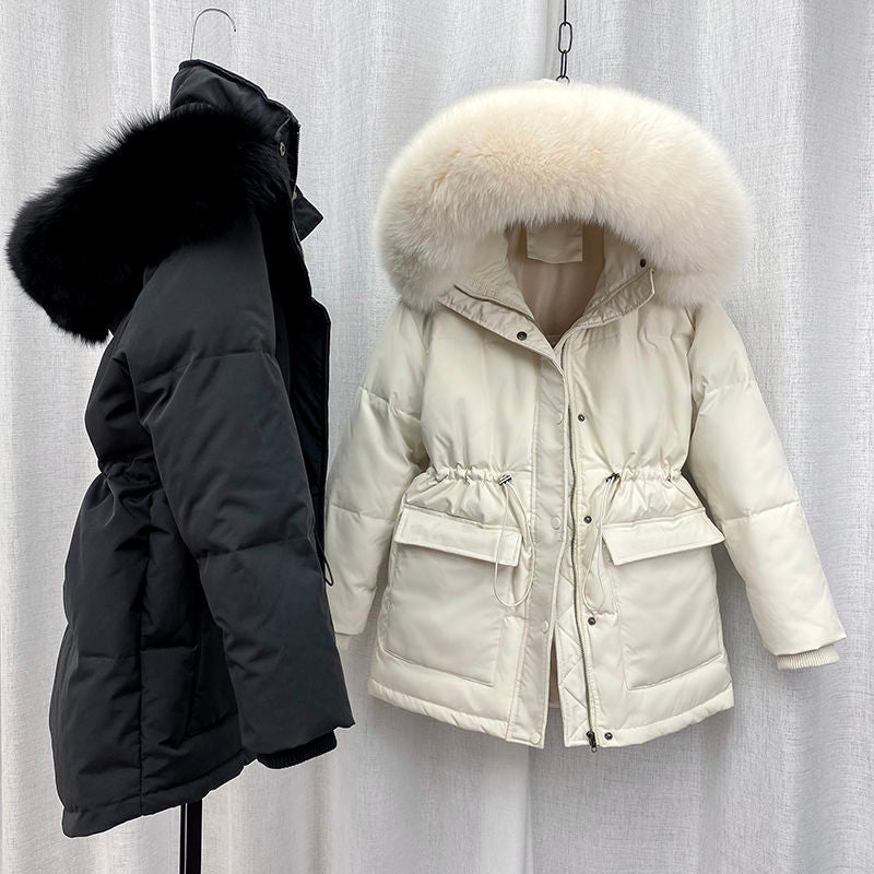 Zwei Winterparkas mit Fellkapuze, schwarz und cremeweiß, auf Kleiderbügeln vor weißem Hintergrund.