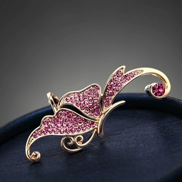 Goldene Schmetterlingsbrosche mit rosa Kristallen, elegantes Schmuckstück, modisches Accessoire.