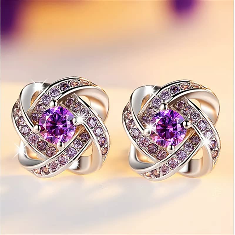 Goldene Ohrringe mit violetten Kristallen, funkelnd, elegantes Schmuckdesign, Damenaccessoire.