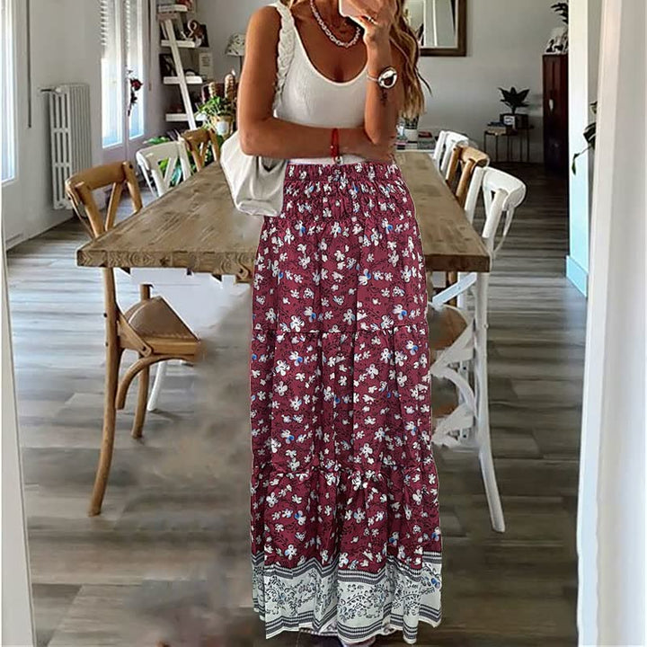 Frau in weißem Top und rotem Blumenrock in modernem Esszimmer.