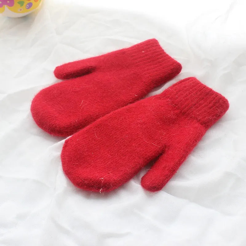 Rote Wollfäustlinge auf weißem Hintergrund, warme Winterhandschuhe, gestrickt.