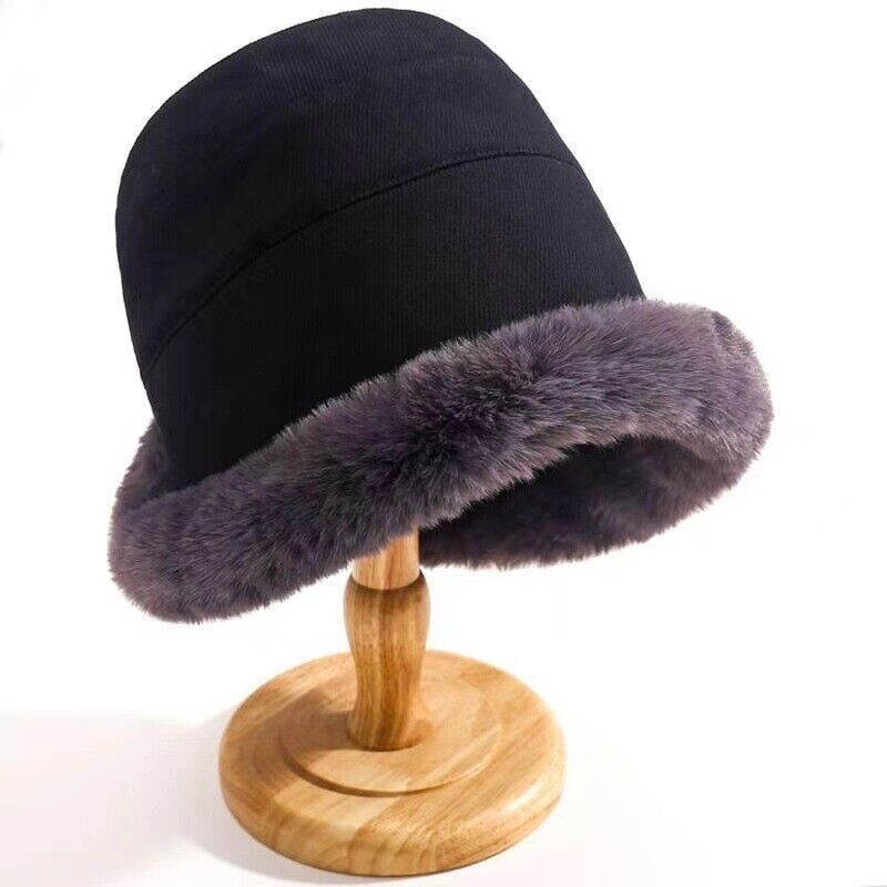 Schwarzer Eimerhut mit grauem Kunstfellrand auf Holzständer, Wintermode Accessoire.